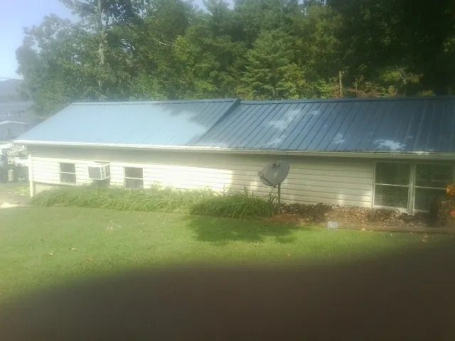 Blue metal roof running the length of a single story home in Massena